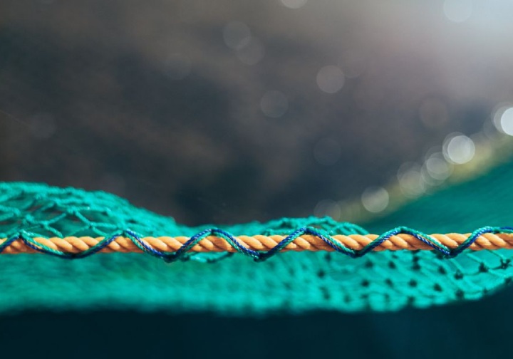 Detalhe de uma rede de pesca, mostrando a trama e os laços que a compõem.
