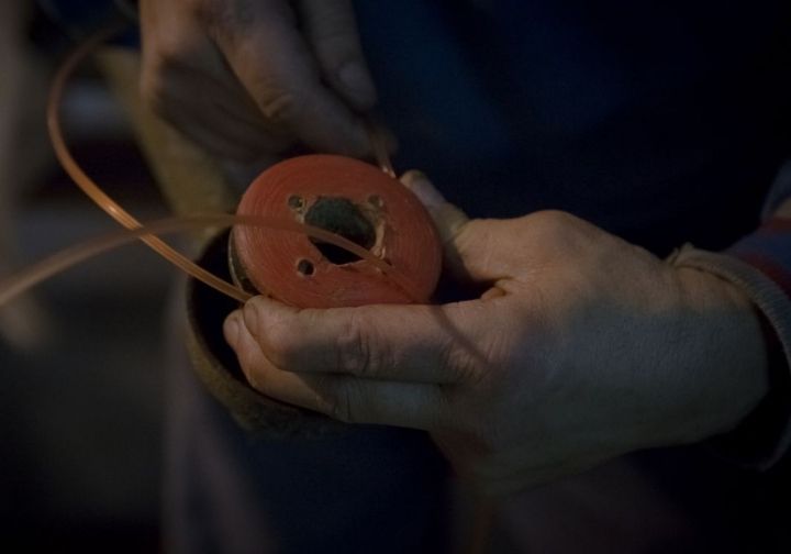 Man winding square-shaped trimmer line around a spool for brush cutters